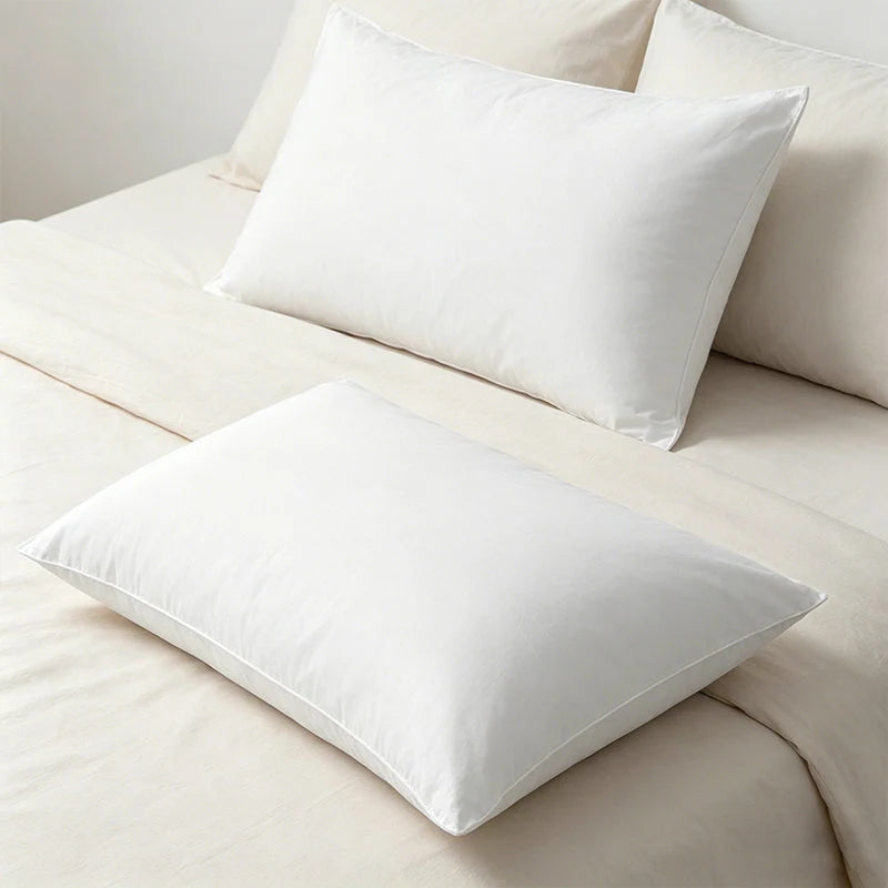 Plump white pillows arranged on an ivory bed
